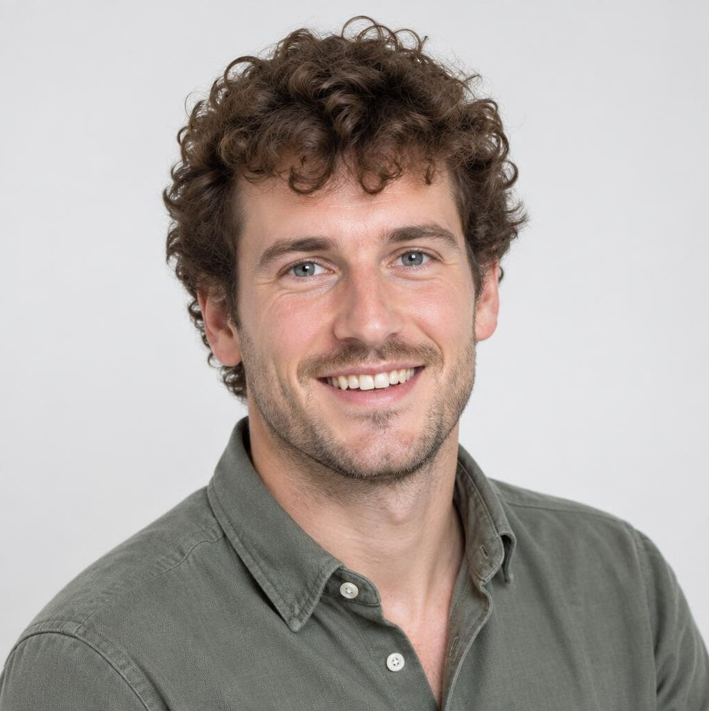 Studio portrait of a young man with curly hair smiling
